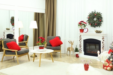 Beautiful living room interior with burning fireplace and Christmas decor