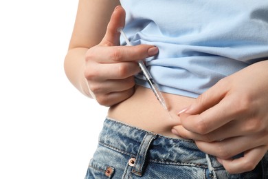 Photo of Diabetes. Woman making insulin injection into her belly on white background, closeup