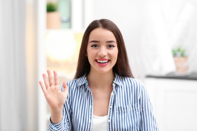 Photo of Beautiful woman using video chat for conversation indoors