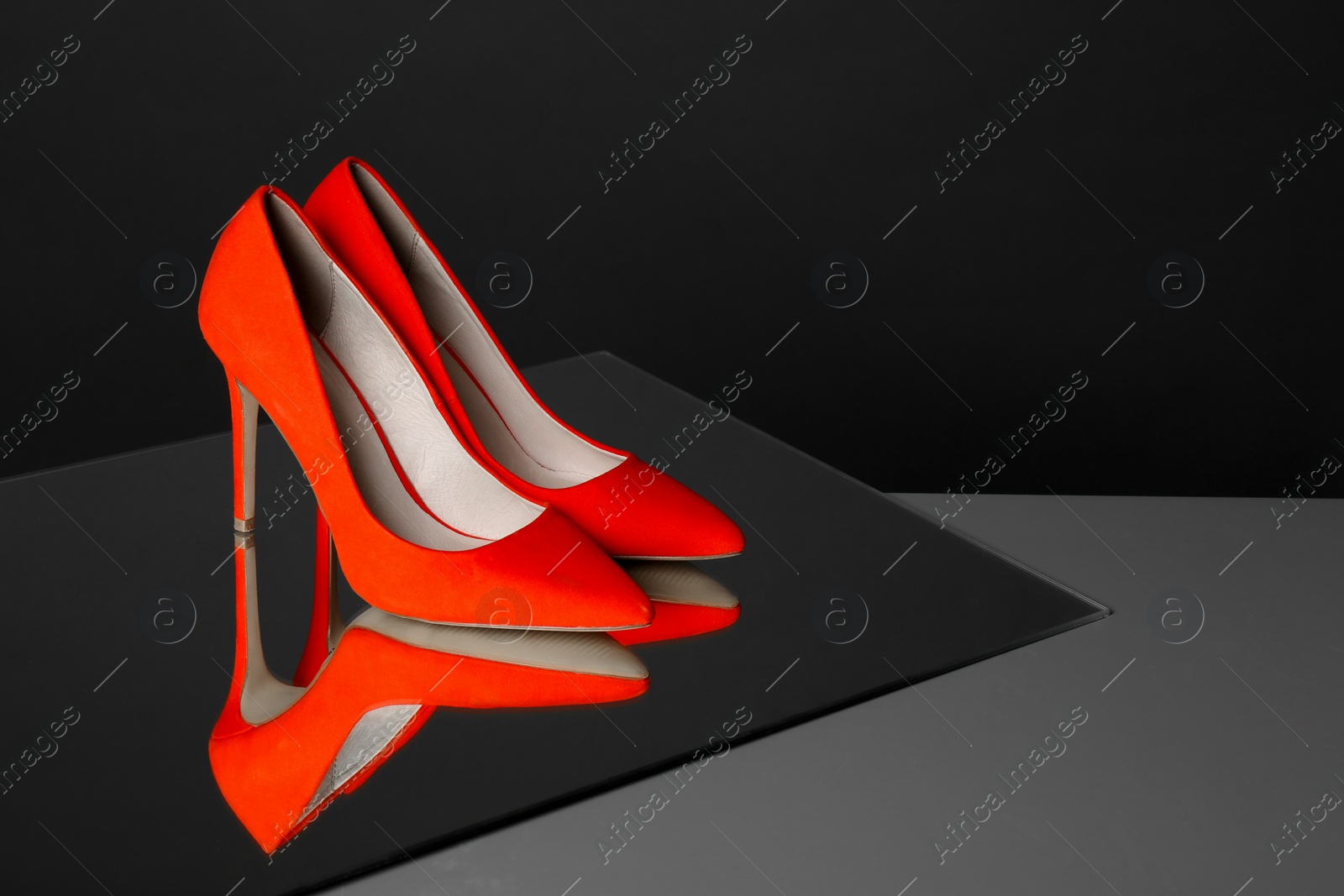 Photo of Pair of lady's shoes on table against black background, space for text