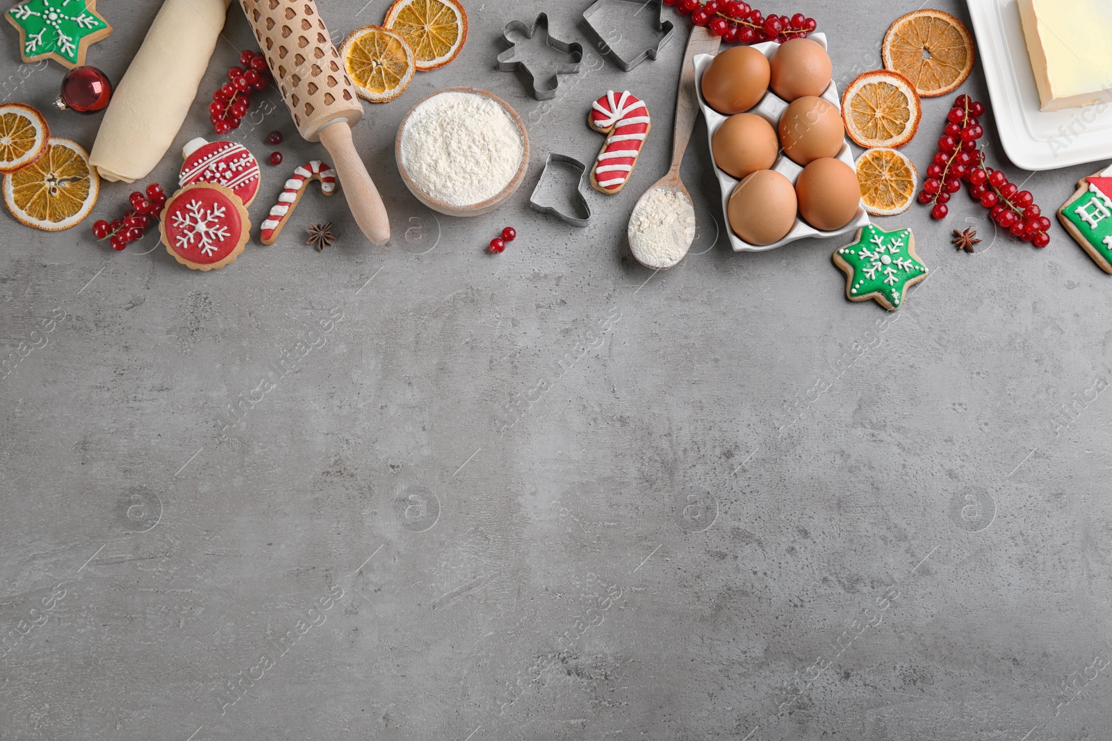 Photo of Flat lay composition with homemade Christmas cookies and ingredients on grey table, space for text