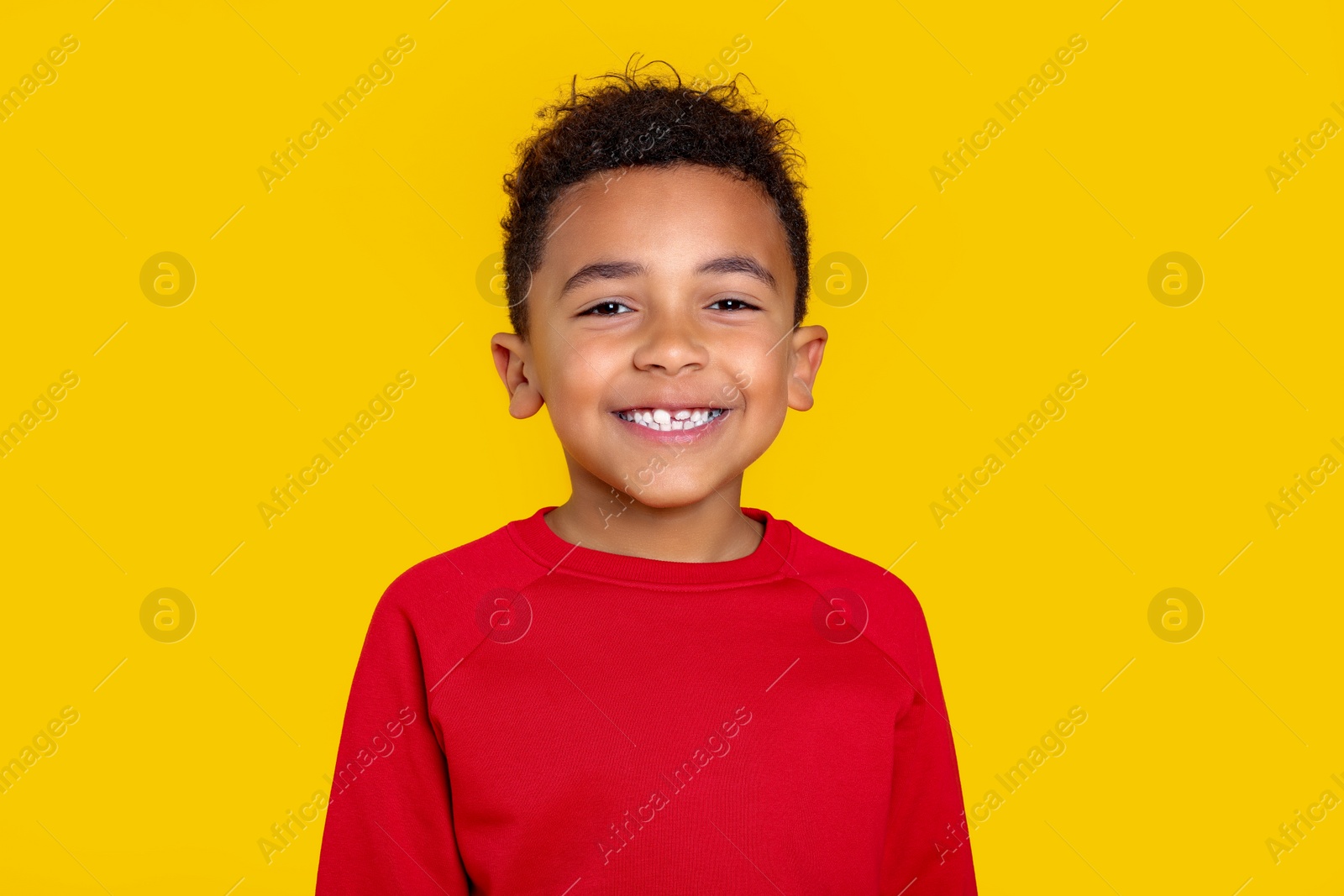 Photo of Portrait of cute African-American boy on yellow background