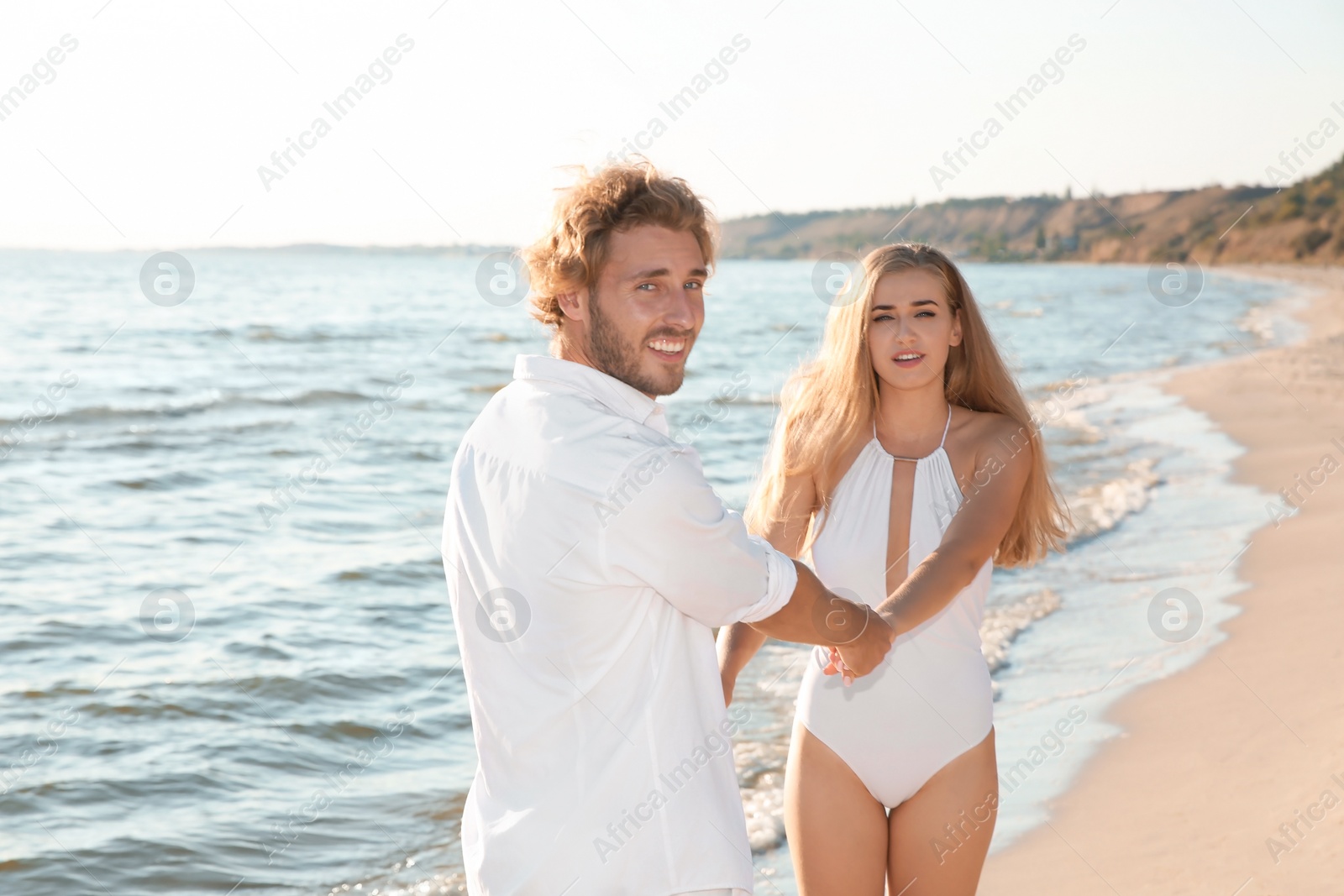 Photo of Romantic young couple dancing together on beach