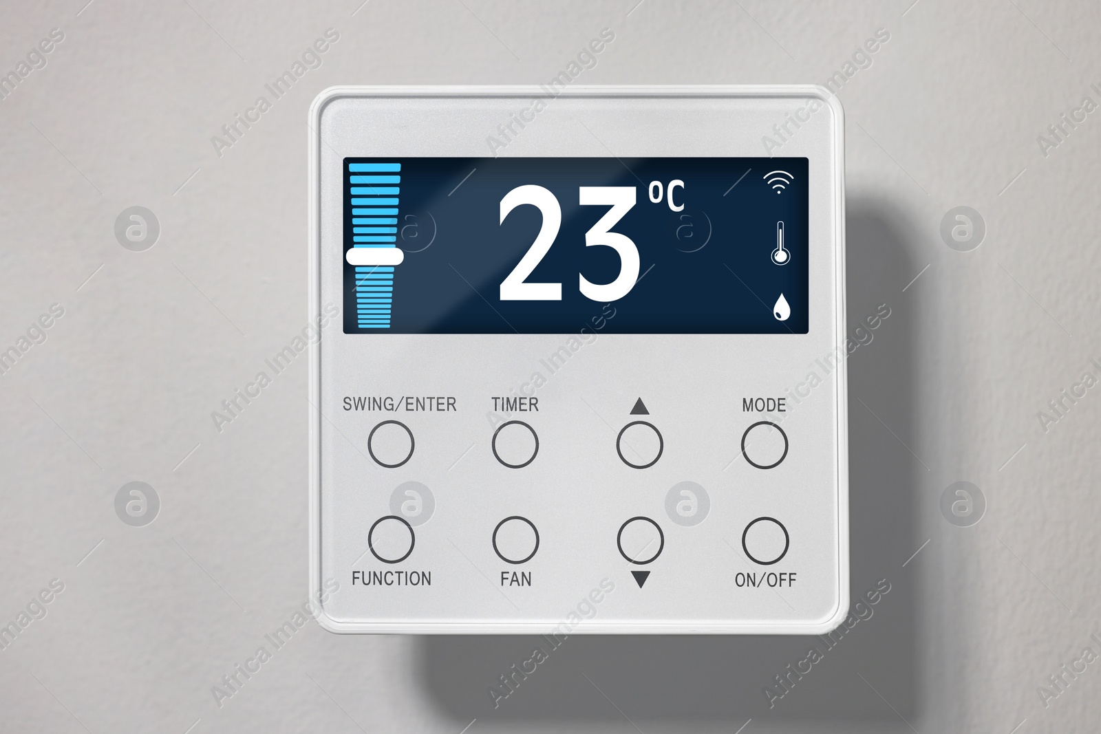 Image of Thermostat displaying temperature in Celsius scale and different icons. Smart home device on light wall