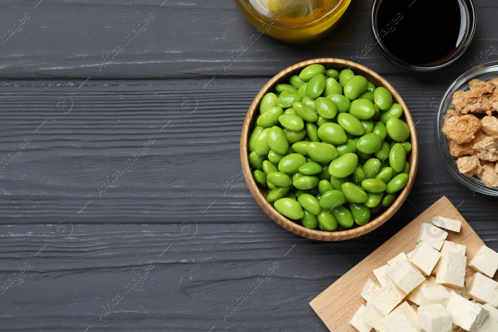 Photo of Different organic soy products on grey wooden table, flat lay. Space for text