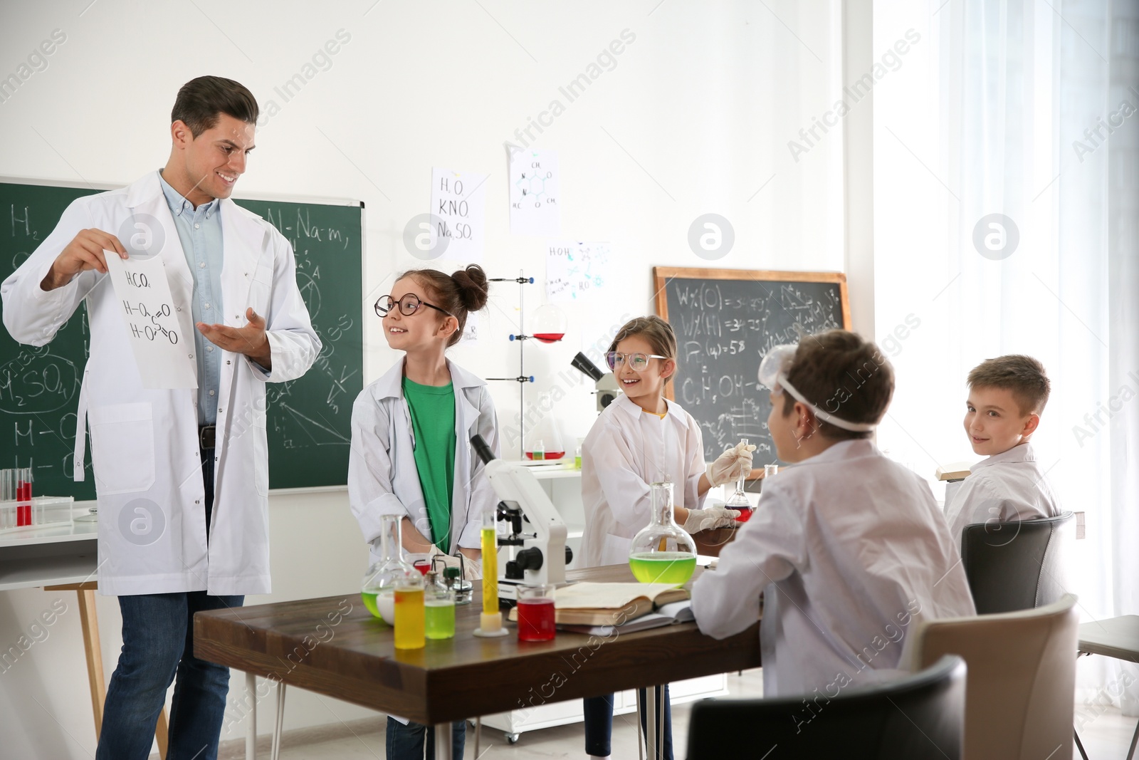 Photo of Teacher with pupils at chemistry lesson in classroom