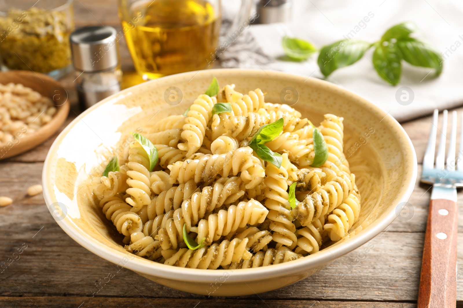 Photo of Plate of delicious basil pesto pasta served for dinner on table