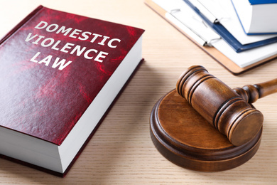 Image of Domestic violence law book and gavel on wooden table