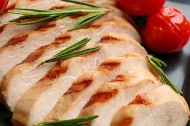 Tasty grilled chicken fillet with rosemary on plate, closeup