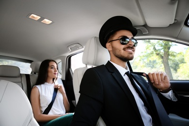 Young businesswoman with handsome driver in luxury car