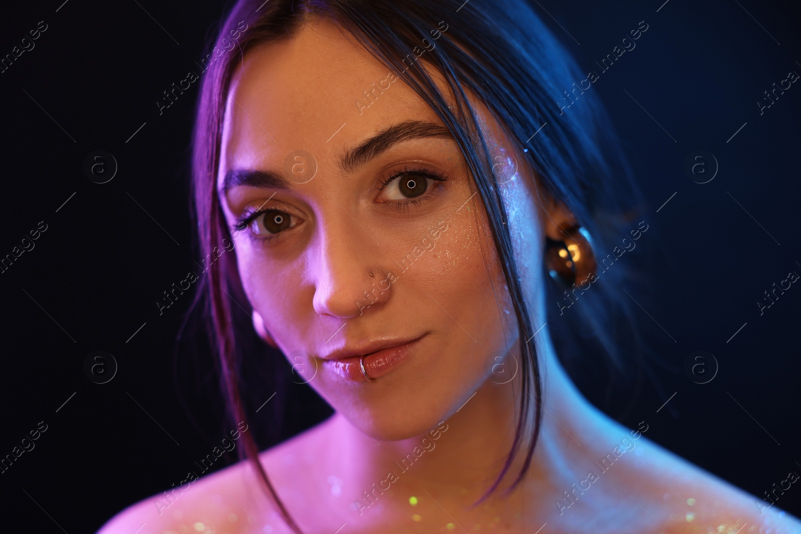 Photo of Portrait of beautiful woman on dark background in neon lights