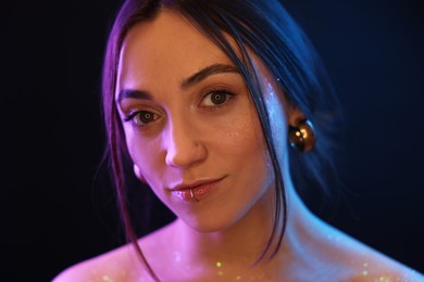 Portrait of beautiful woman on dark background in neon lights