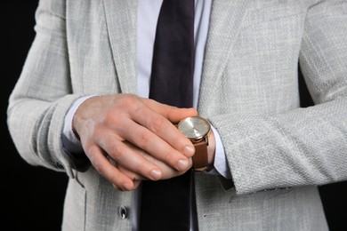 Businessman wearing wristwatch, closeup view. Time management