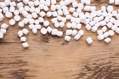 Photo of Delicious marshmallows on wooden table, flat lay. Space for text