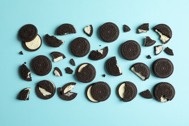 Tasty chocolate cookies with cream on color background, flat lay