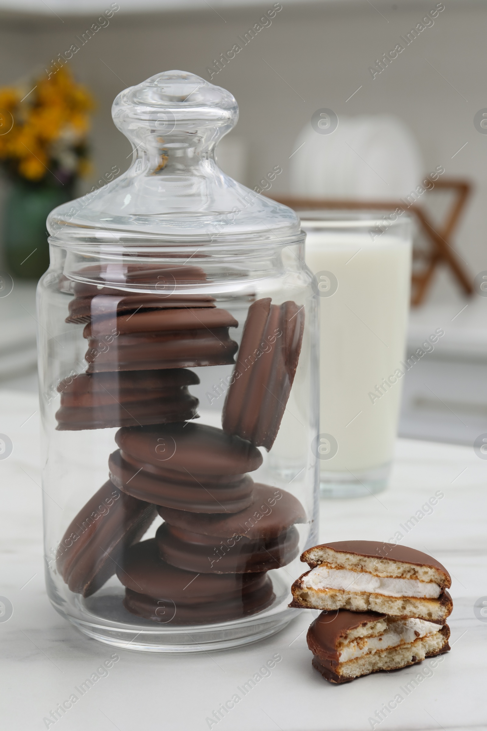 Photo of Jar with delicious choco pies and glass of milk on white table in kitchen