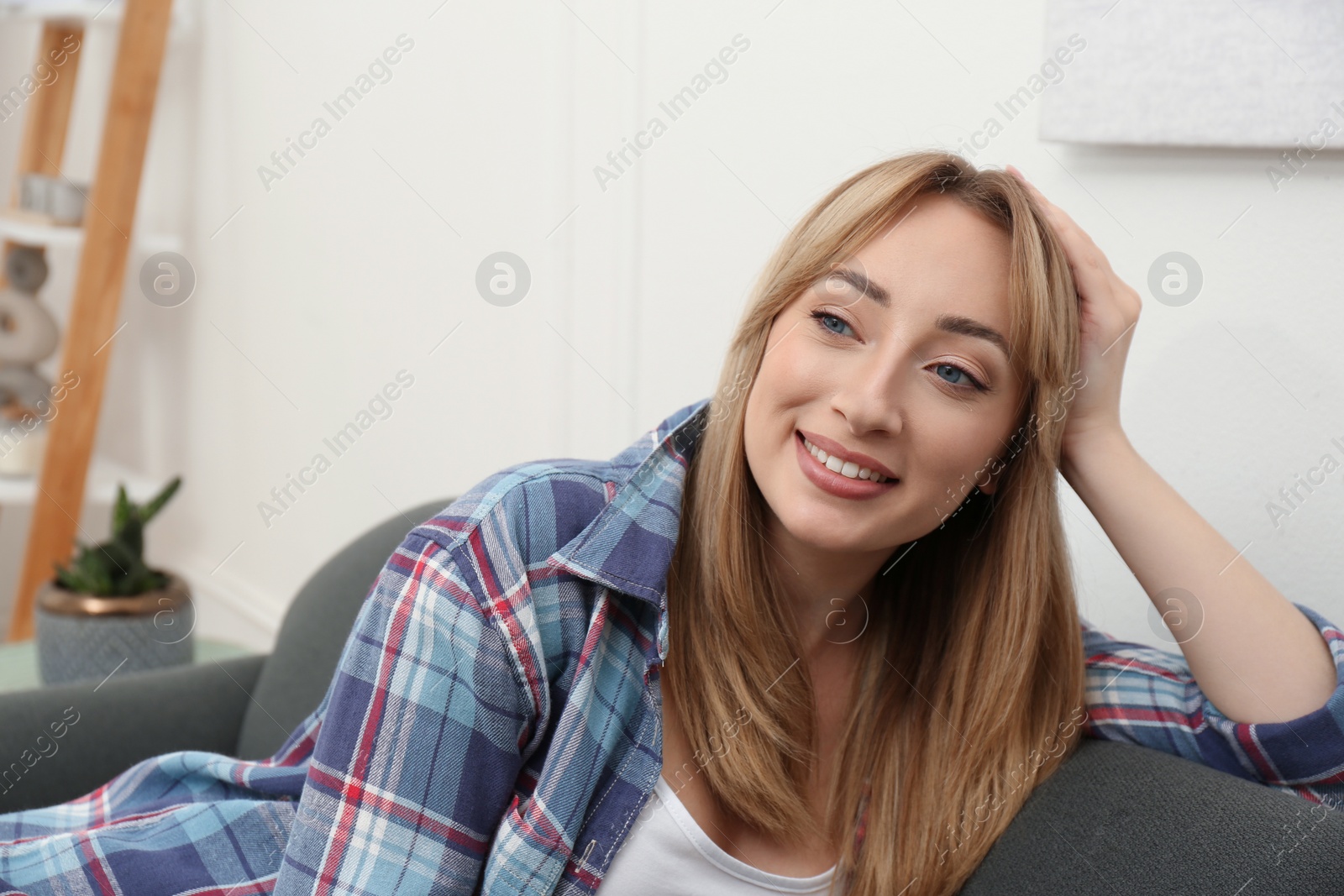 Photo of Beautiful young woman relaxing on sofa at home