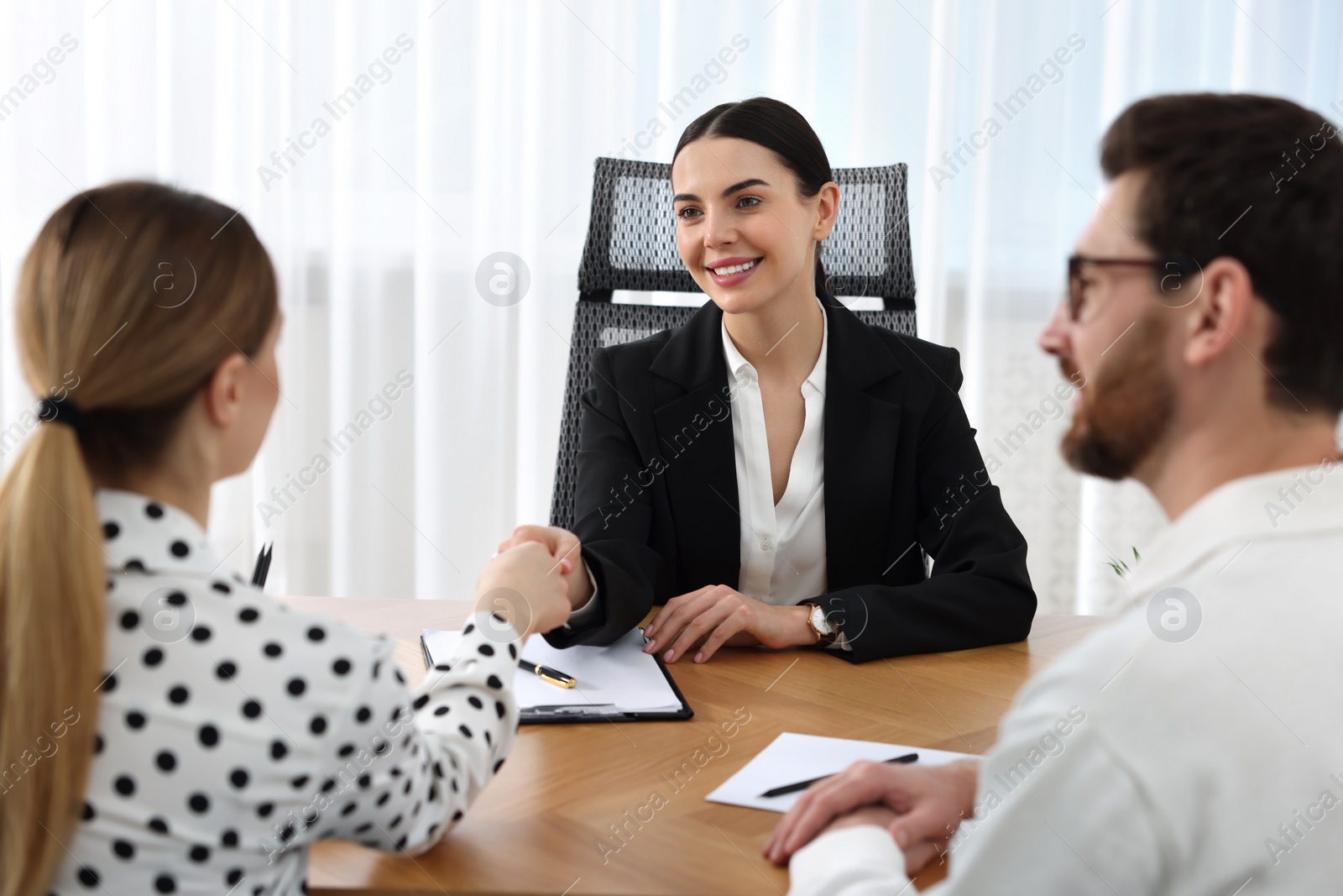 Photo of Lawyer shaking hands with clients in office