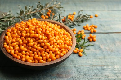 Ripe sea buckthorn berries on blue wooden table