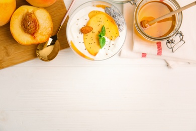 Photo of Tasty peach dessert with yogurt and chia seeds served on white wooden table, flat lay. Space for text