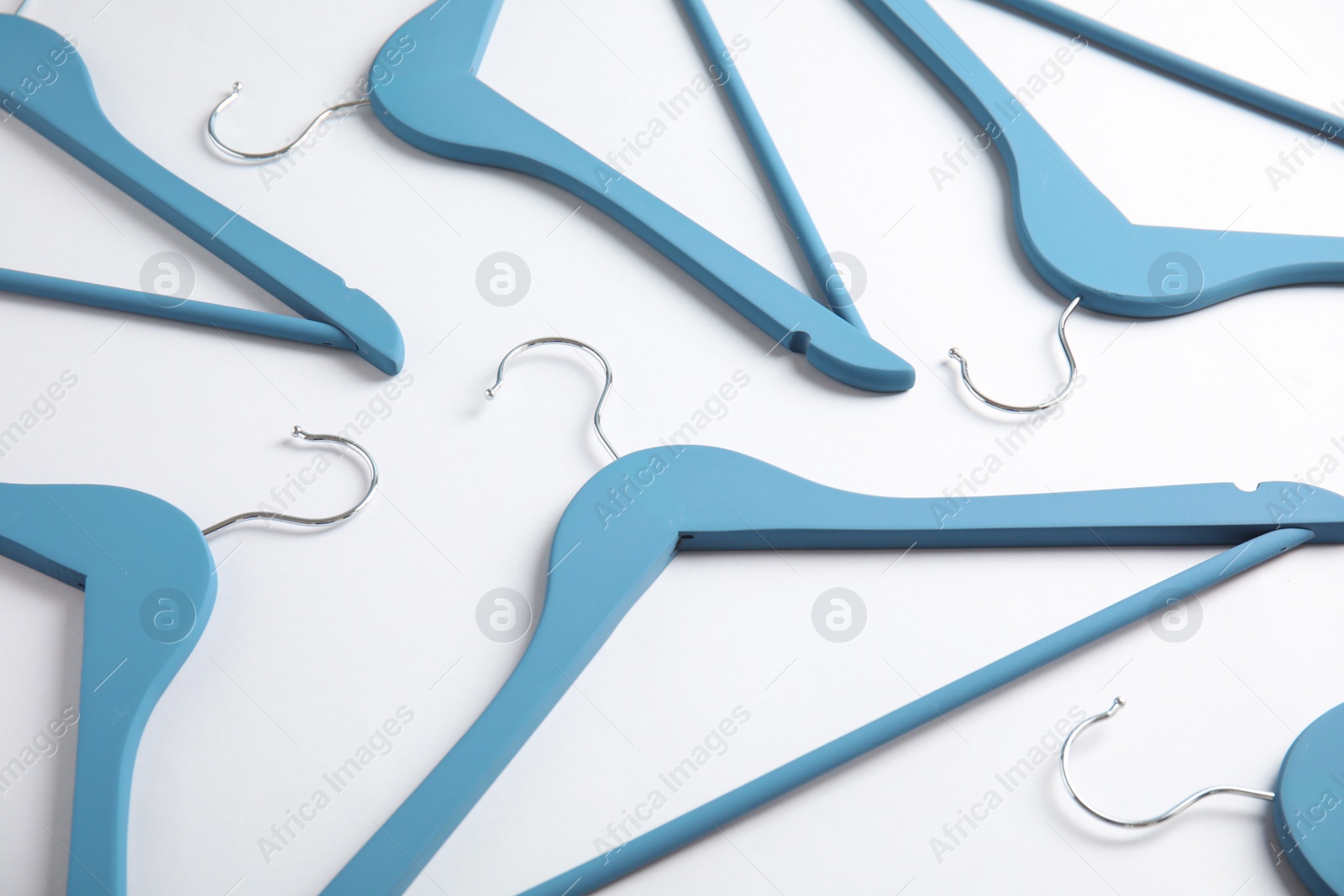 Photo of Empty wooden clothes hangers on white background