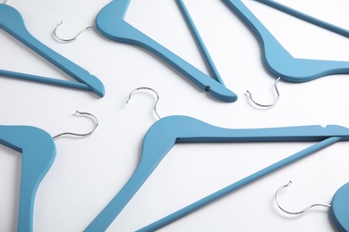 Photo of Empty wooden clothes hangers on white background