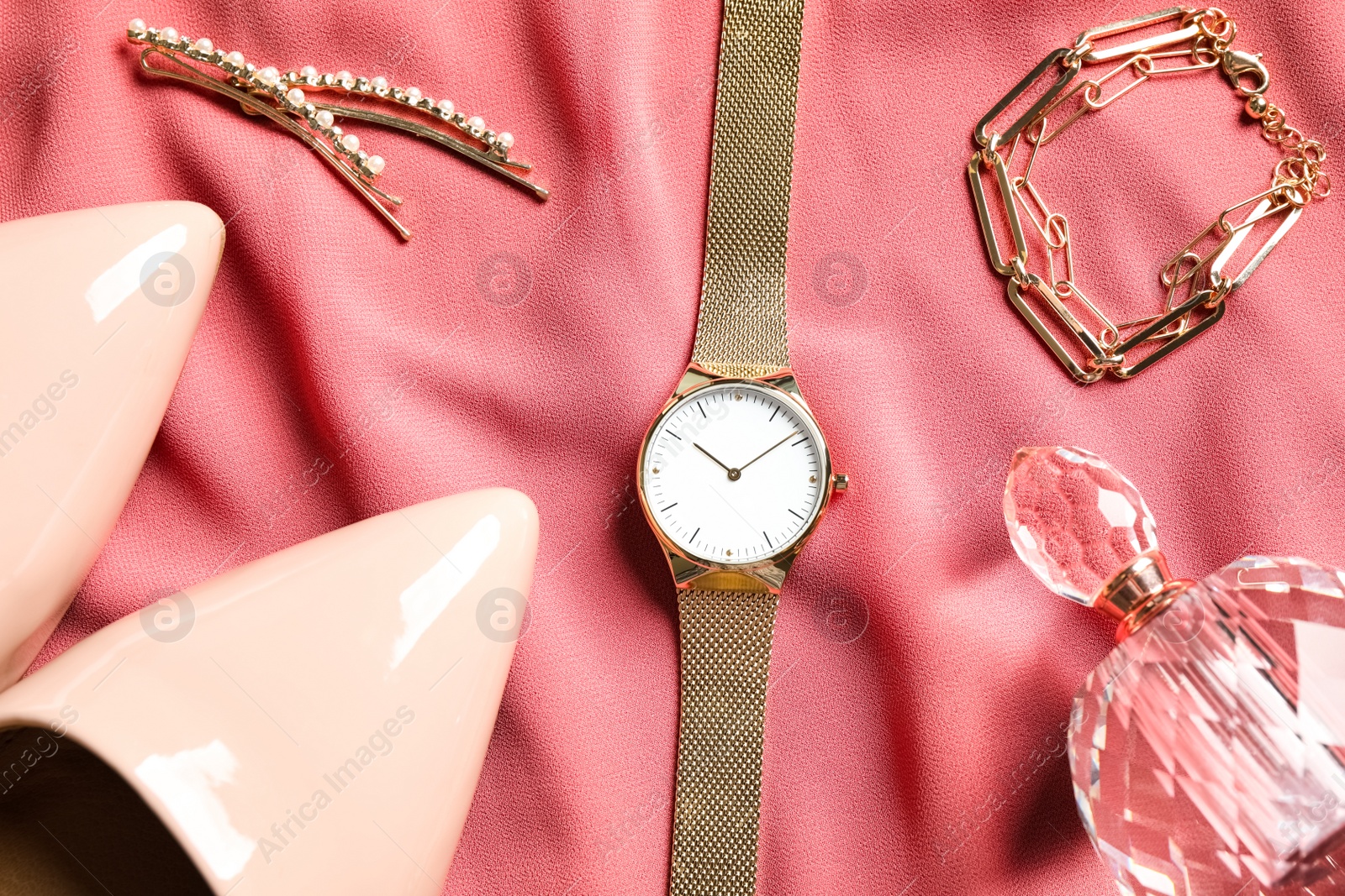 Photo of Flat lay composition with luxury wrist watch on pink fabric