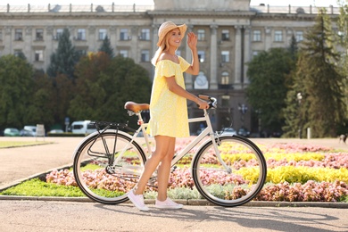 Photo of Beautiful happy woman with bicycle on street