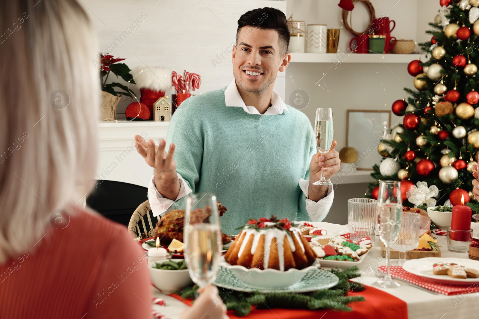 Photo of Happy family with their friends enjoying festive dinner at home. Christmas Eve celebration