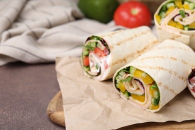 Photo of Delicious sandwich wraps with fresh vegetables on grey table, closeup