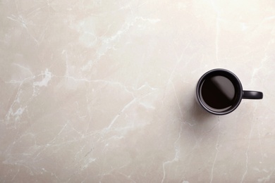 Photo of Ceramic cup with hot aromatic coffee on marble background, top view