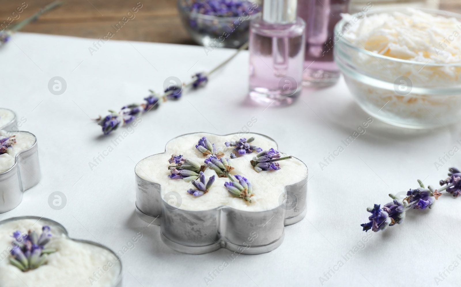 Photo of Handmade soap bar with lavender flowers in metal form on white paper. Space for text