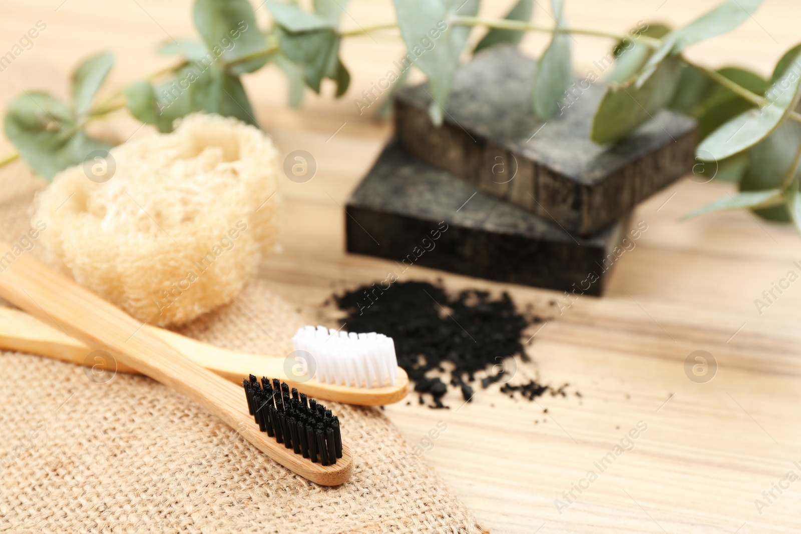 Photo of Natural toothbrushes made with bamboo on wooden table