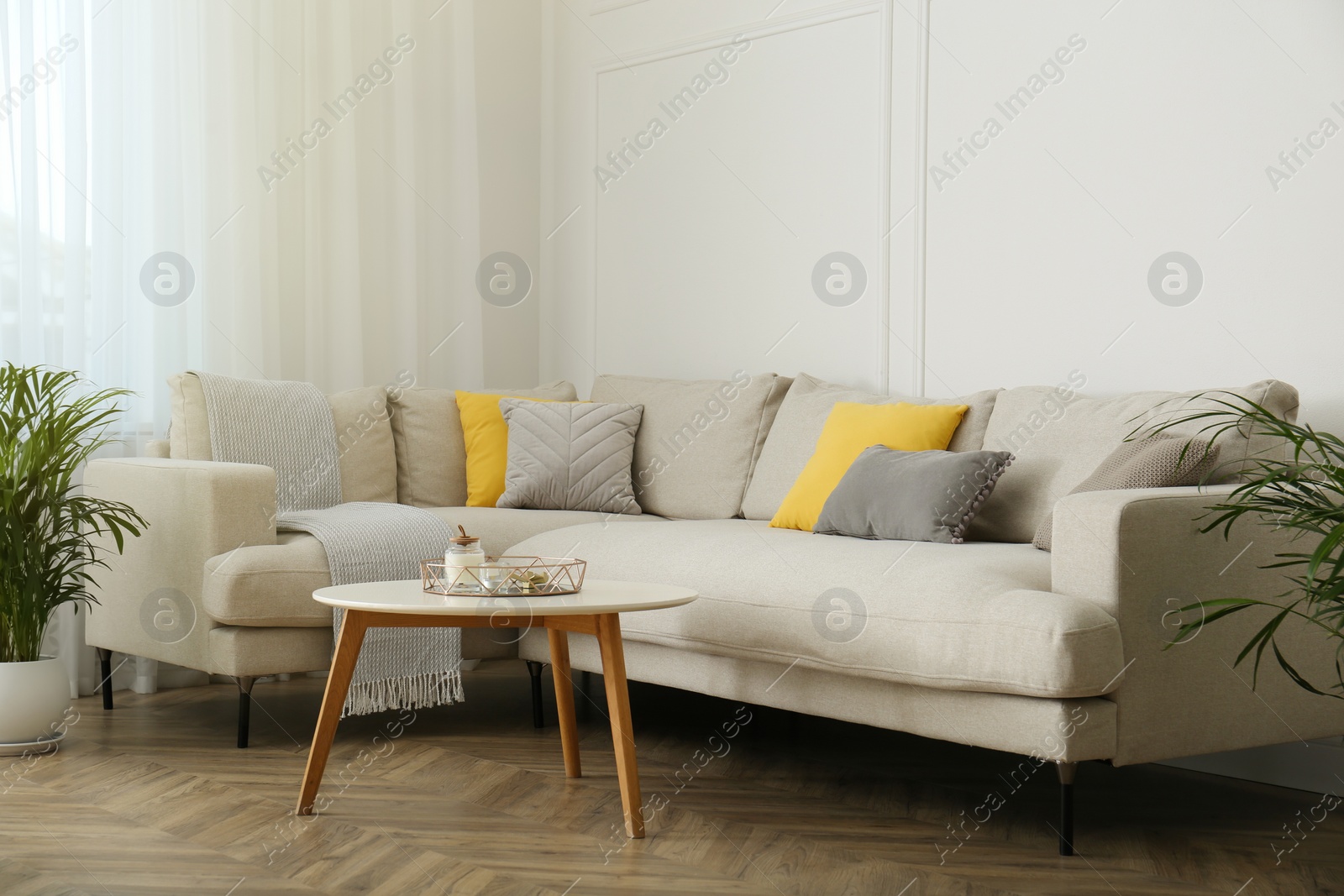 Photo of Stylish beige sofa in living room interior