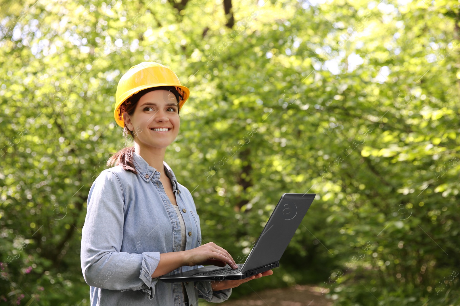 Photo of Forester with laptop examining plants in forest, space for text