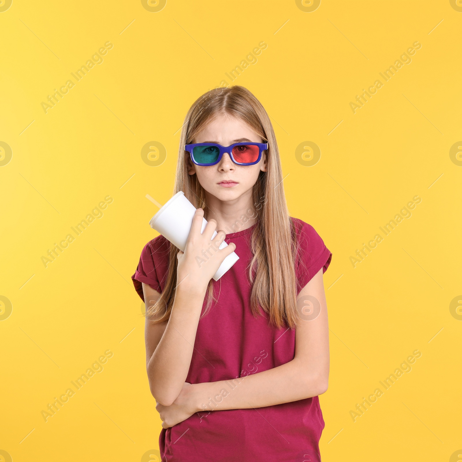 Photo of Emotional teenage girl with 3D glasses and beverage during cinema show on color background