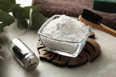 Tooth powder, brush and floss on light grey table, closeup