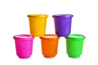 Photo of Colorful containers with play dough on white background