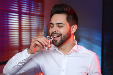 Photo of Young man with Mexican Tequila shot in bar