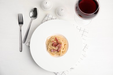 Photo of Delicious Carbonara pasta served on white wooden table, flat lay