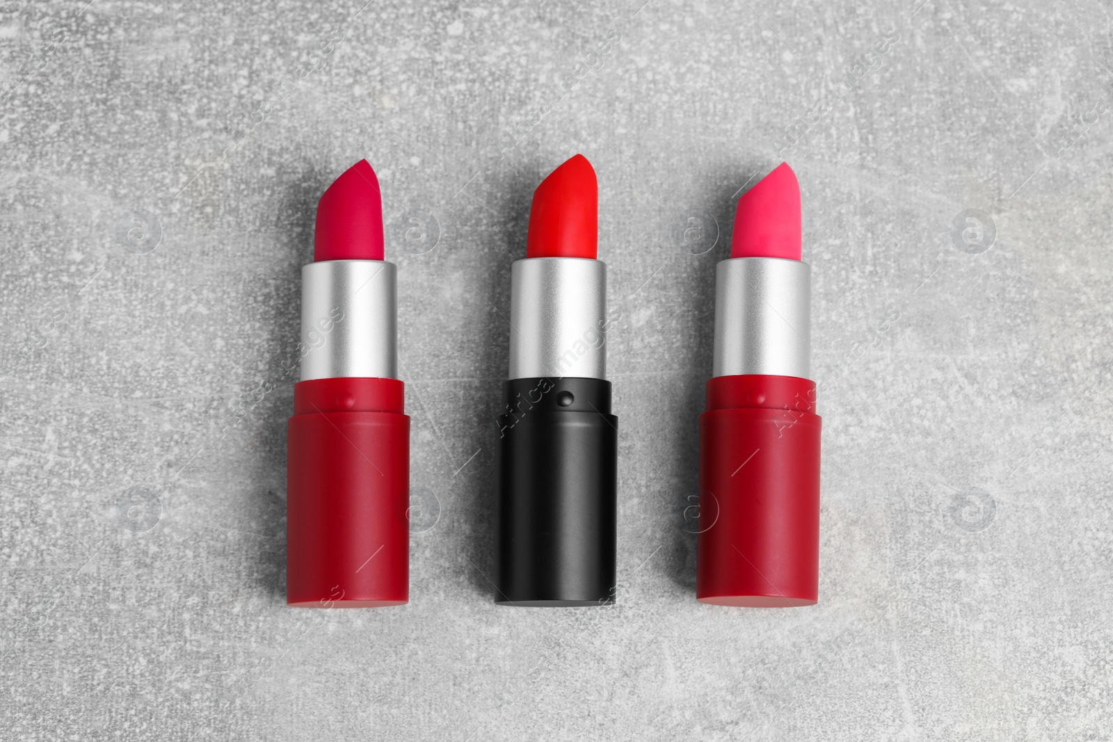 Photo of Different lipsticks on grey table, flat lay