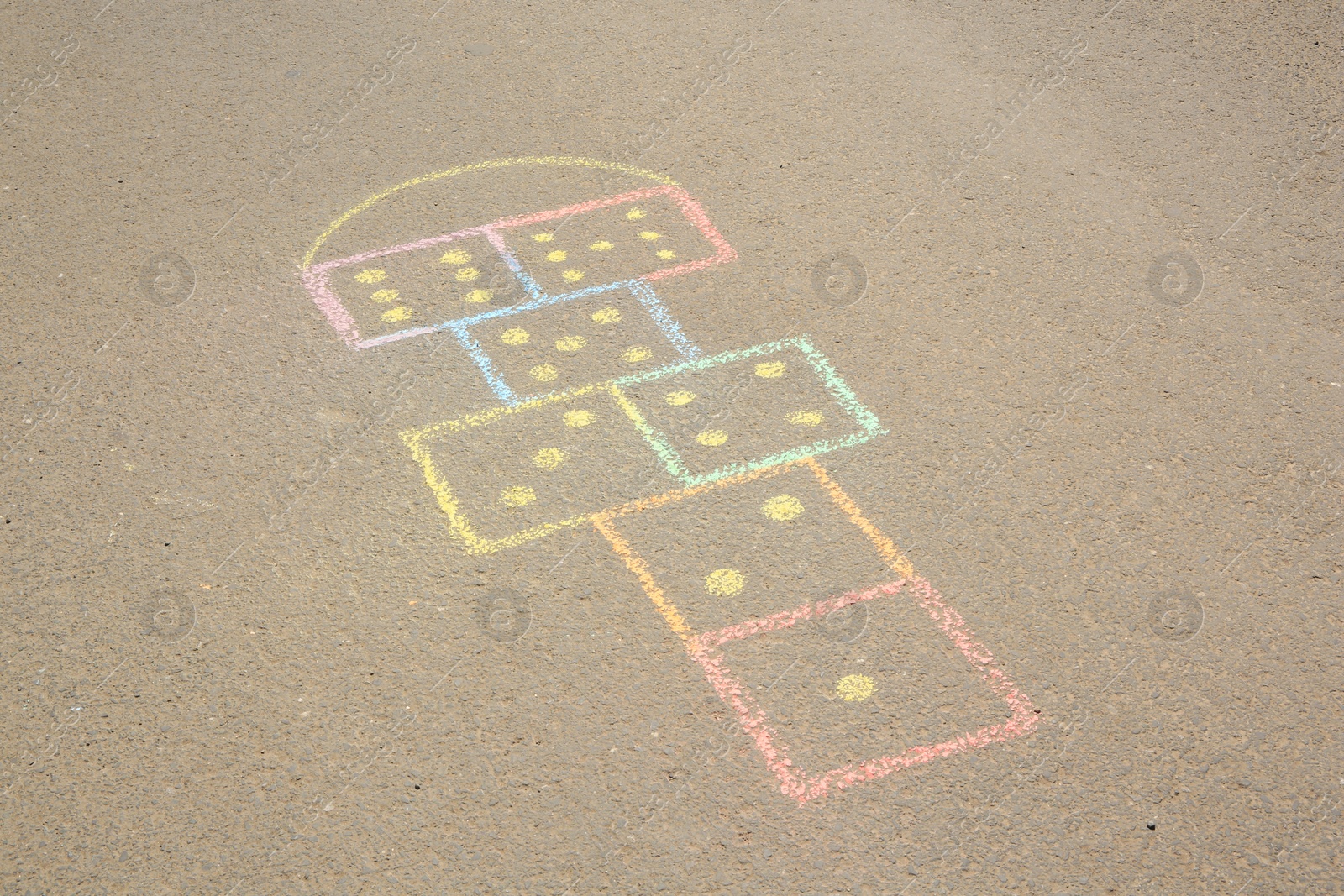 Photo of Hopscotch drawn with colorful chalk on asphalt outdoors