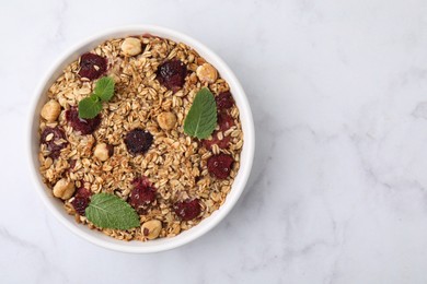 Tasty baked oatmeal with berries and nuts on white marble table, top view. Space for text