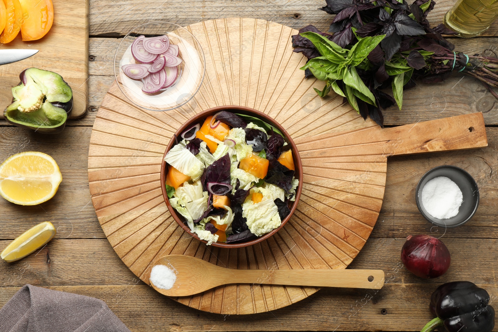 Photo of Delicious salad with Chinese cabbage, tomato and basil served on wooden table, flat lay