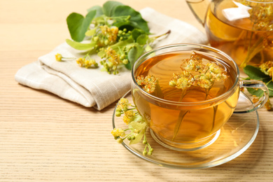 Cup of tea with linden blossom on wooden table