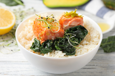 Photo of Tasty salmon with rice and spinach on white wooden table