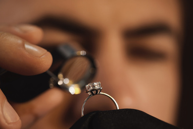 Photo of Jeweler working with ring on blurred background, closeup