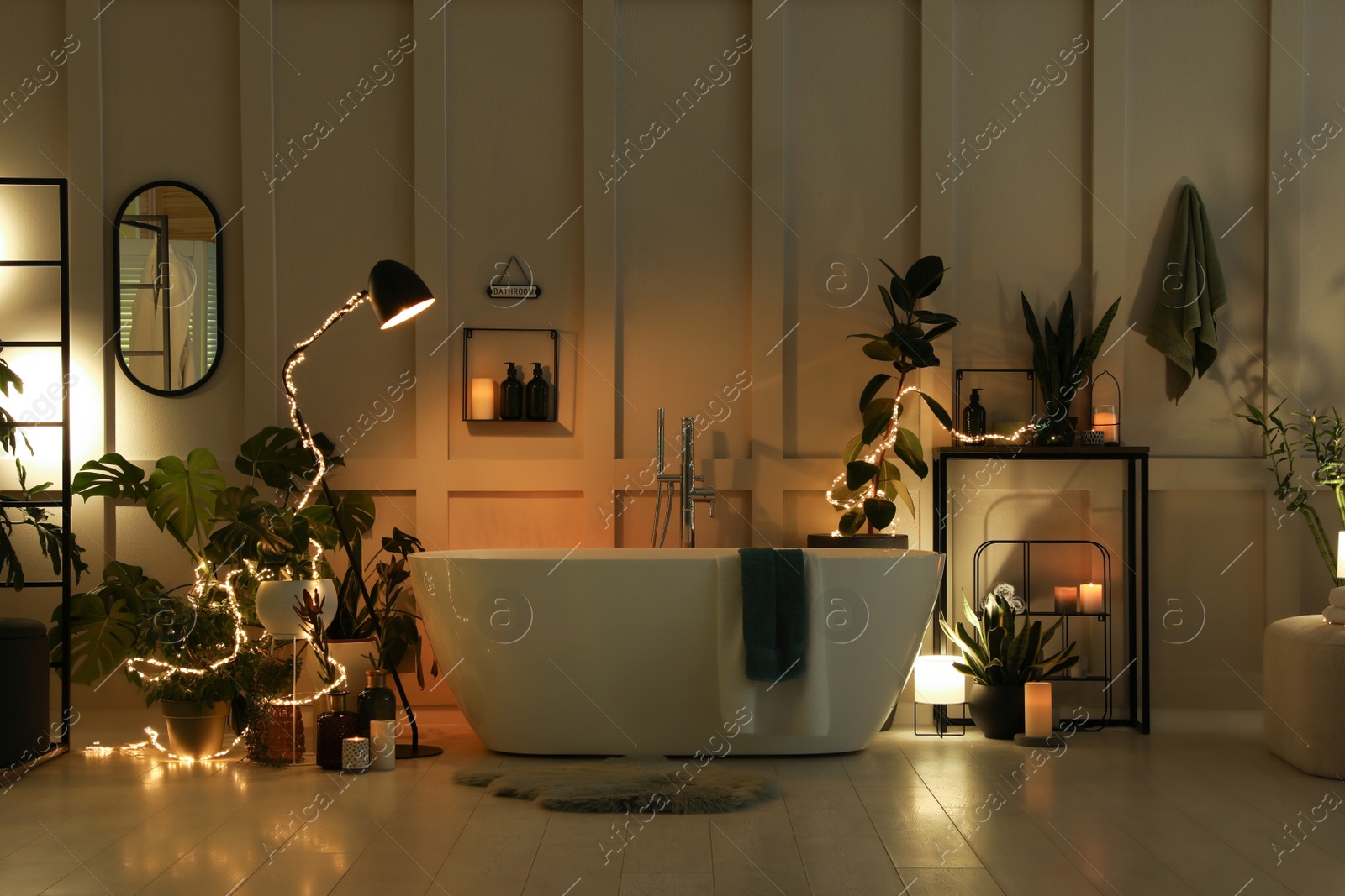 Photo of Stylish bathroom interior with houseplants and string lights. Home design