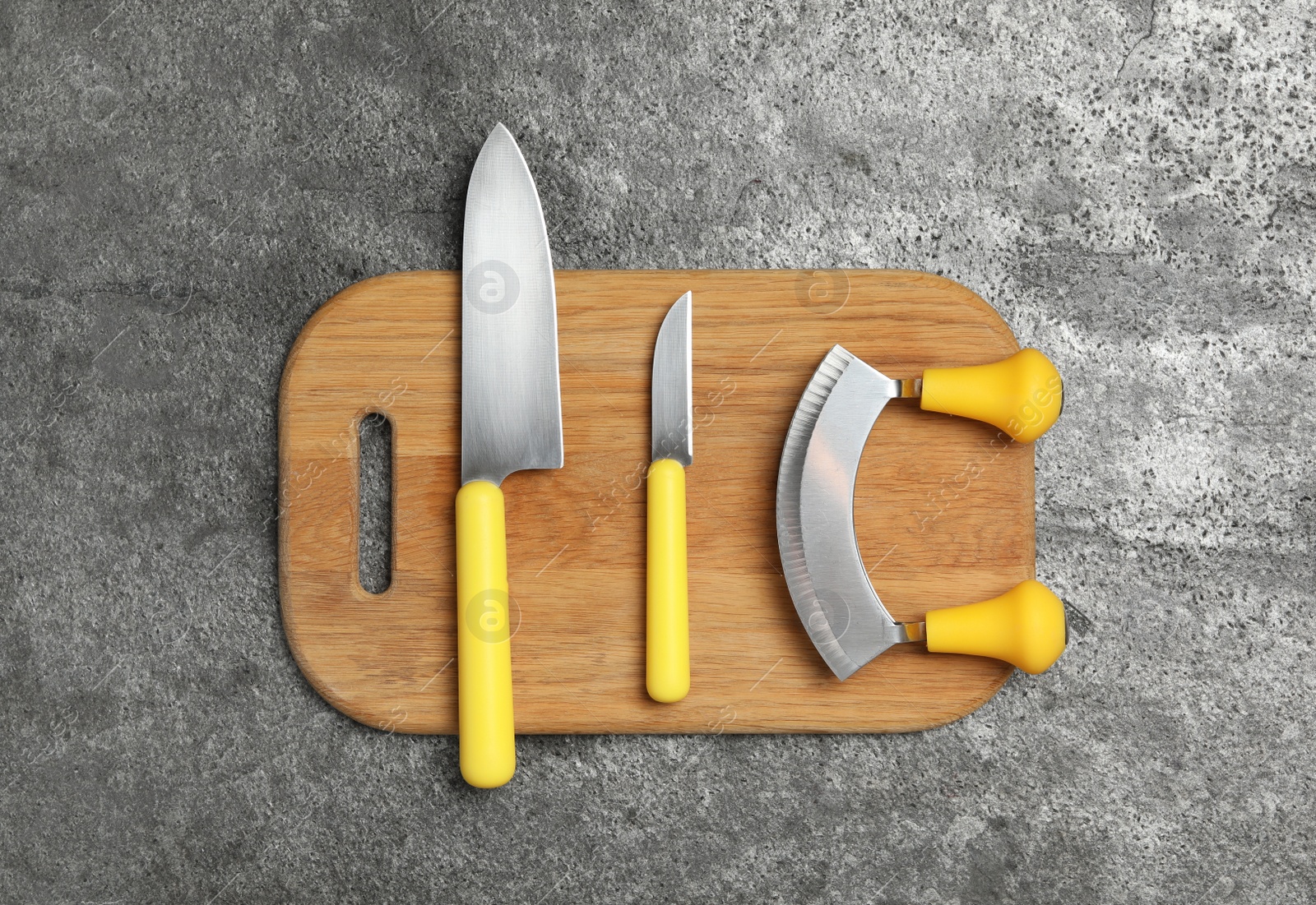 Photo of Set of knives on grey table, top view. Cooking utensils