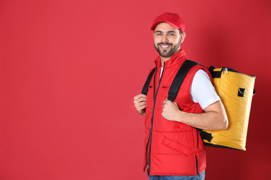 Courier with thermo bag on red background, space for text. Food delivery service